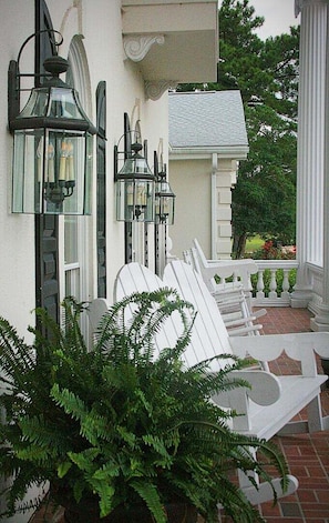 A porch with white chairs and a potted fern. - Family Friendly Villa 1202 with 27 Hole Golf Course Available and Great Resort Amenities by RedAwning (Calabash)