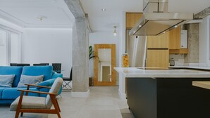 A modern kitchen with a central island, wooden cabinets, and a stainless steel range hood. - Tribuna - Victoria 8 (Málaga)