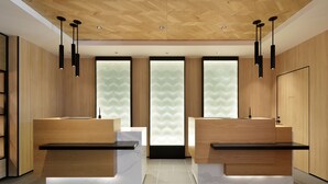 A modern reception area with two reception desks, wooden paneling, and a herringbone ceiling. - Fairfield by Marriott Tochigi Motegi (Motegi)