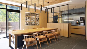 A modern kitchen with a wooden island, black pendant lights, and a large window overlooking greenery. - Fairfield by Marriott Tochigi Motegi (Motegi)