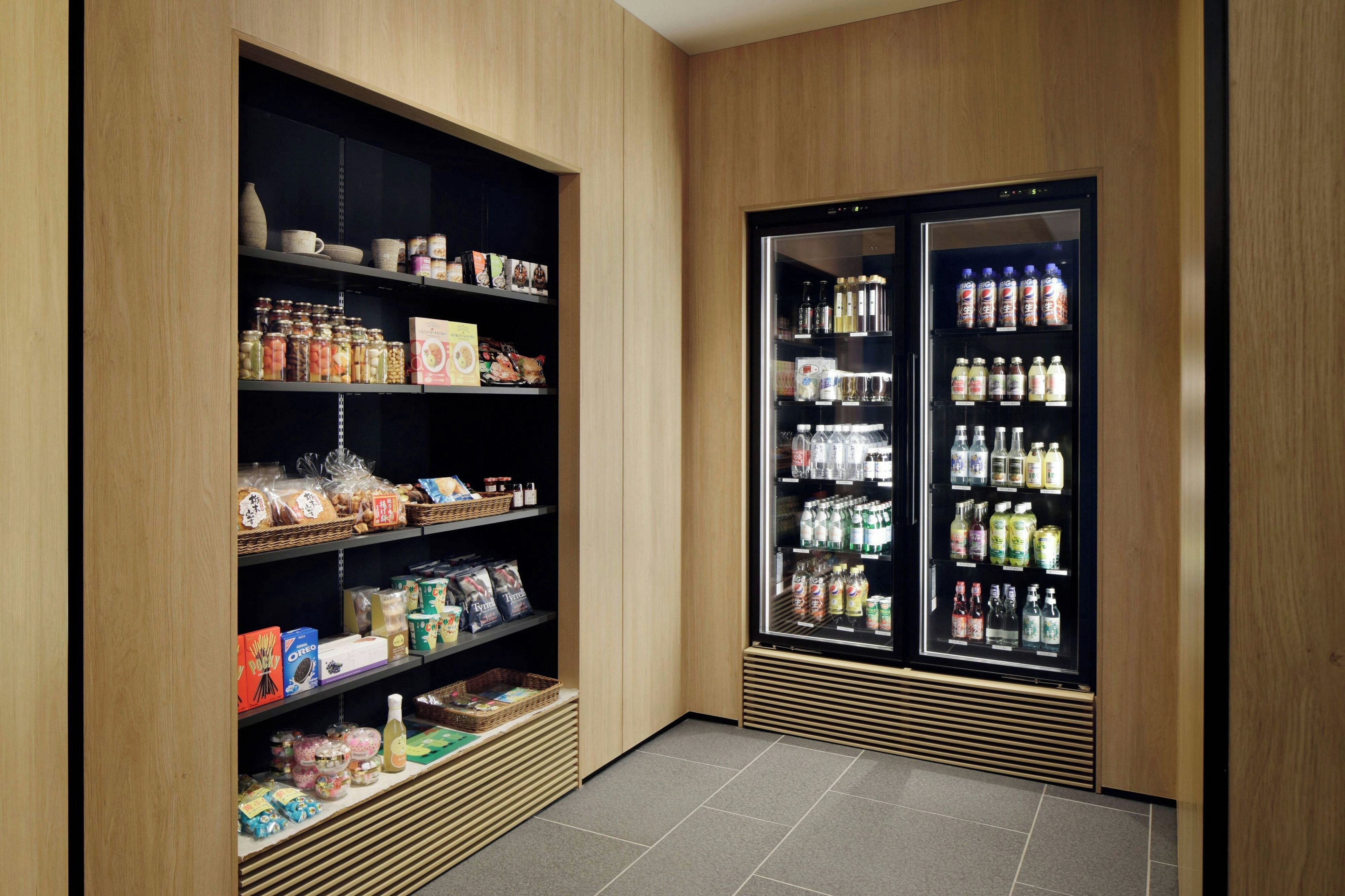 A storage area with shelves stocked with various food items and a refrigerator containing beverages.