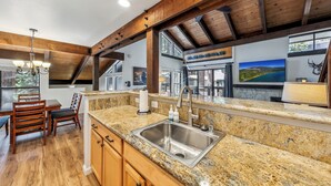 A kitchen with granite countertops, wooden cabinets, and a stainless steel sink.
