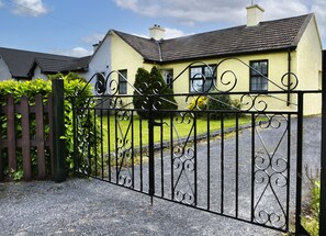 A gated entrance to a house with a driveway leading to the front door. - Garden Cottage (Clogheen)
