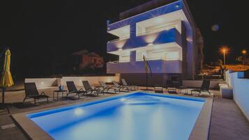 Relax by the pool surrounded by lounge chairs in this contemporary building.
