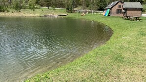 Un chalet au bord du lac, doté d’un quai, entouré d’une zone herbeuse et d’arbres.