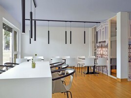 A modern conference room with a long table, white chairs, and pendant lighting.