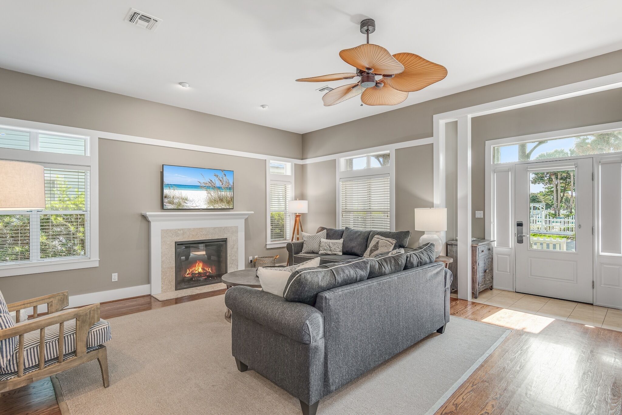 A living room with a fireplace, a sofa, a coffee table, and a ceiling fan.