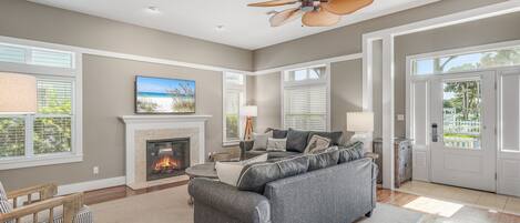 A living room with a fireplace, a sofa, a coffee table, and a ceiling fan.