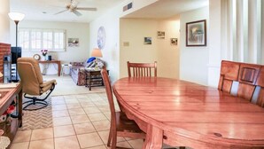 A spacious dining area with a large wooden table and chairs, a ceiling fan, and a window with blinds. - Stay and Play! *Golfers Retreat *Budget Friendly (Prescott)
