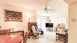 A living room with a dining table, chairs, a sofa, a TV, and a fireplace. - Stay and Play! *Golfers Retreat *Budget Friendly (Prescott)