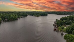 Un río con casas a sus orillas, rodeado de árboles.