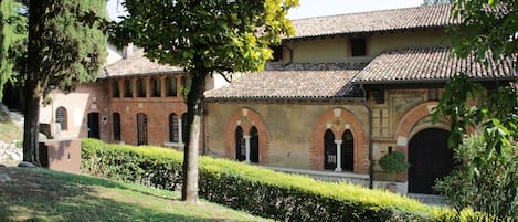 A courtyard with a building featuring arched windows and a tiled roof.
