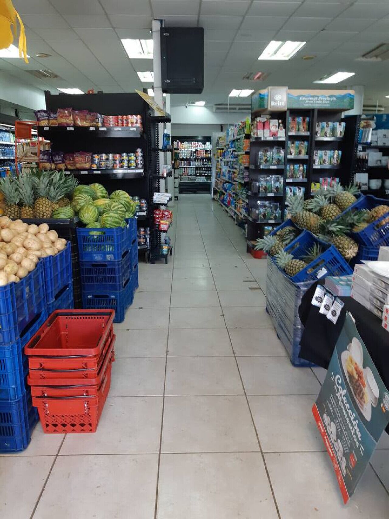 A grocery store aisle with produce and packaged goods.