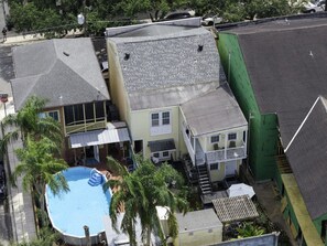 A residential area with a swimming pool, multiple houses, and a green building under construction.