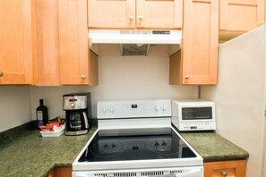 Cozinha equipada com fogão, micro-ondas e cafeteira.