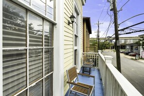 A residential building with a balcony, a chair, and a table. - Creole Cottage, Designer, Balcony (New Orleans)