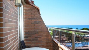 A balcony with a round table and two chairs, overlooking a pool and a view of the ocean. - Don Angel Hotel (Santa Susanna)