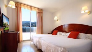 A hotel room with two beds, a TV, and a view of the sea. - Don Angel Hotel (Santa Susanna)