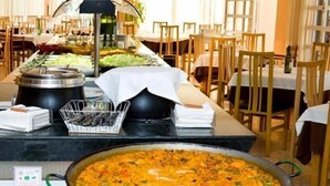 A buffet setup with a large pot of rice and vegetables, a salad bar, and a variety of dishes. - Riviera Beach Apartments (Pilar de la Horadada)