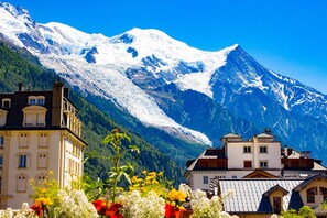 A mountain landscape with snow-capped peaks and a town with traditional architecture.