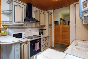 A compact kitchen with a microwave, toaster, and coffee maker. - Le Brevent apartment, Skiing, Chamonix All Year (Chamonix)