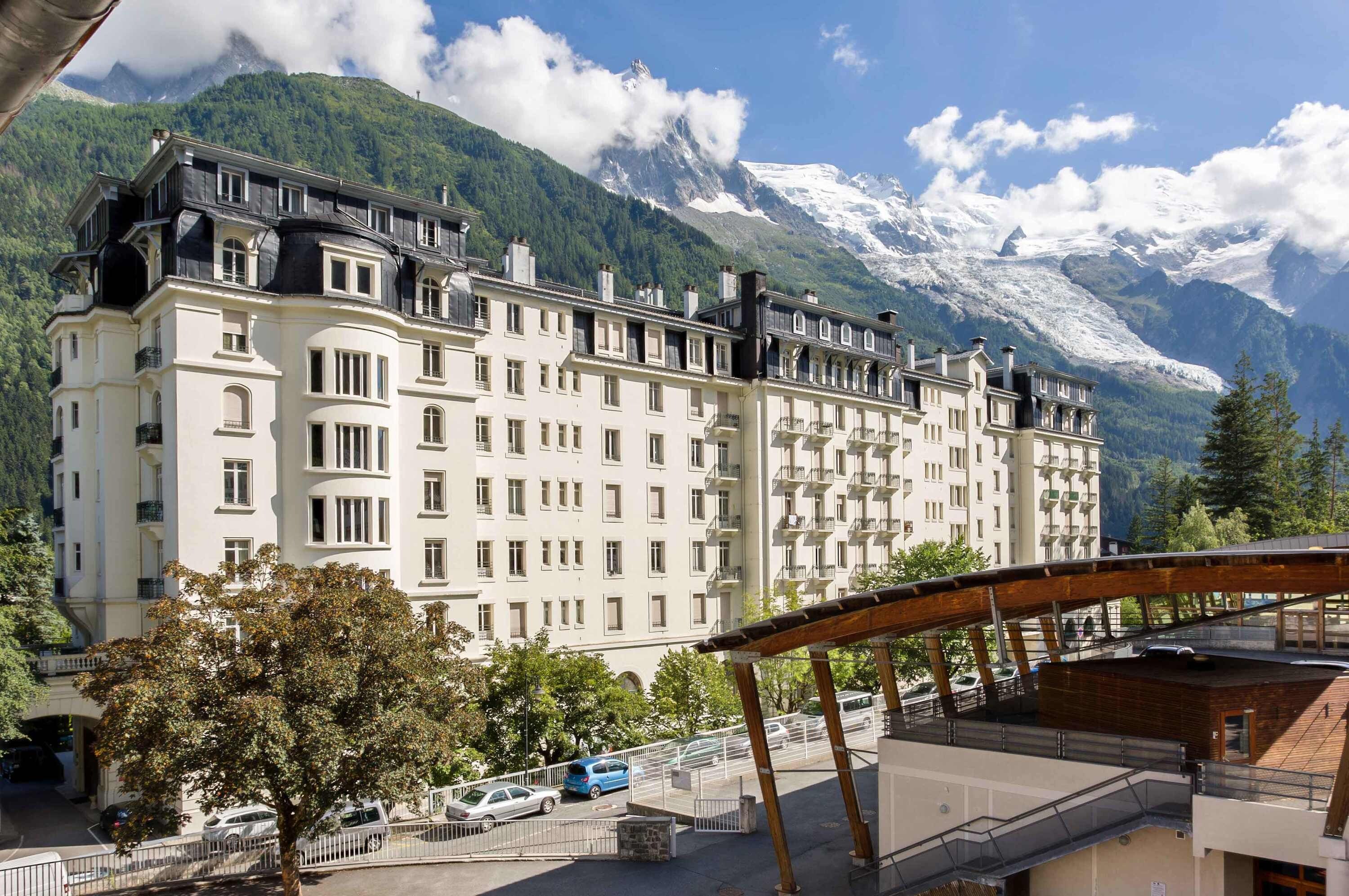 Ein mehrstöckiges Hotel im klassischen europaischen Architekturstil, mit einer symmetrischen Fassade und gleichmäßig verteilten Fenstern und Balkonen.