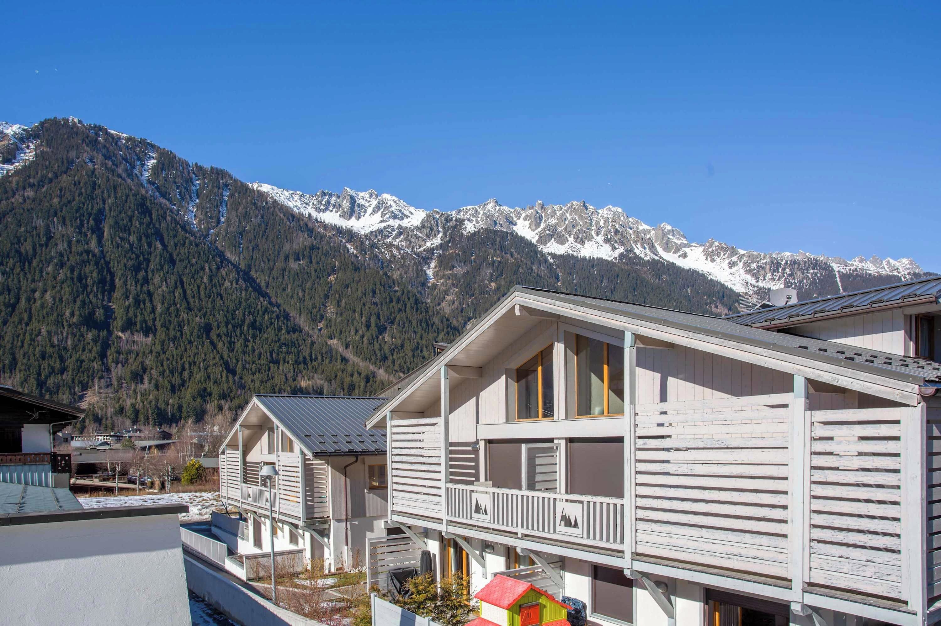 Eine Bergliege mit Balkon, umgeben von schneebedeckten Gipfeln.