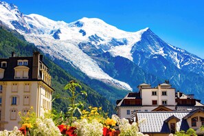 A mountain landscape with snow-capped peaks and a valley with buildings.
