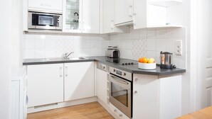 A modern kitchen with white cabinets, a microwave, a toaster, and a blender on the counter.