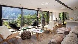 Una sala de estar moderna con ventanas amplias, chimenea y asientos cómodos.