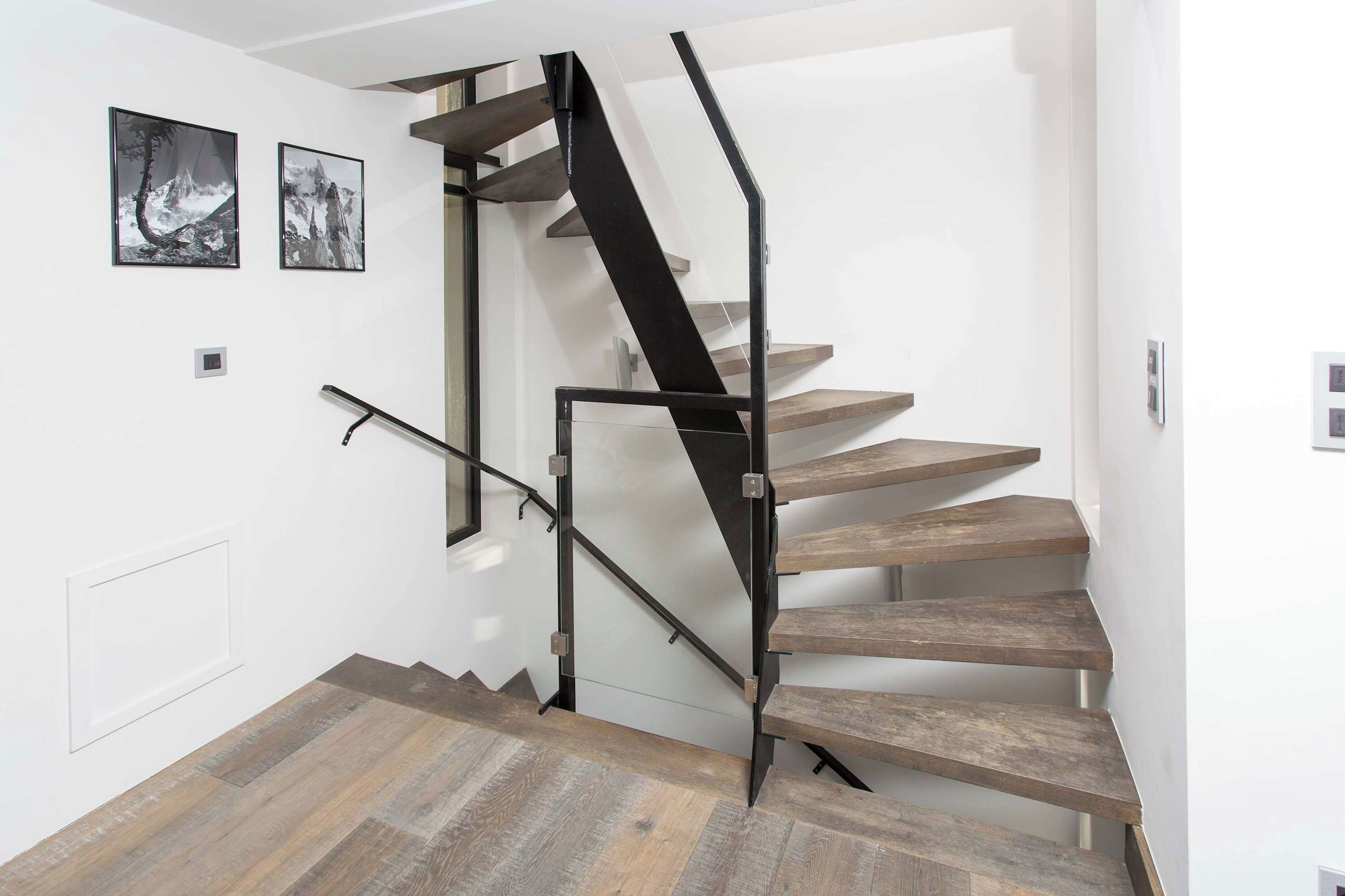 A staircase with wooden steps and a black metal railing.