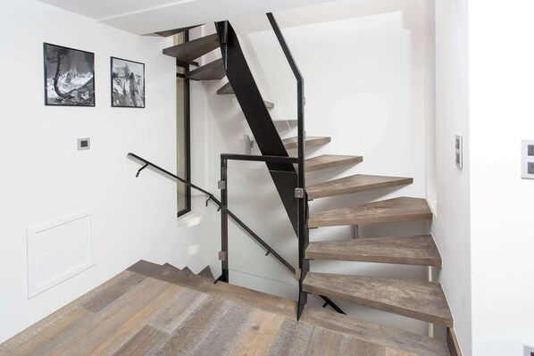 A staircase with wooden steps and a black metal railing.