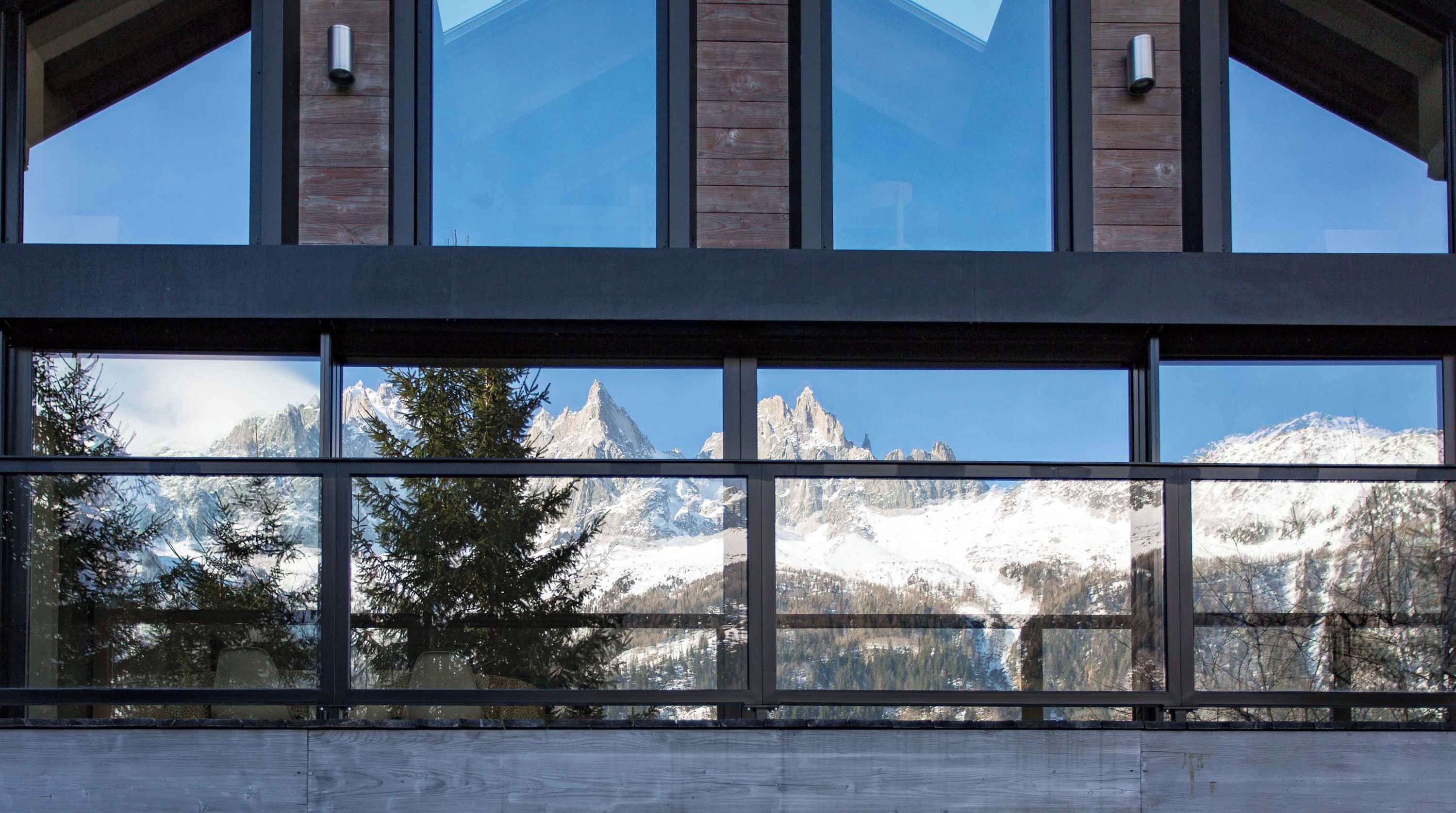 Un edificio moderno con amplios ventanales y vistas a la montaña.