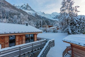 A wooden cabin with a balcony, surrounded by snow-covered trees and mountains. - Chalet de l'Ours, Mt Blanc views, Chamonix All Year (Chamonix)