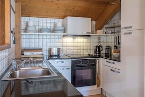 A modern kitchen with a stainless steel sink, a built-in oven, and a coffee maker. - Villa Vallet Apartment, Skiing, Chamonix All Year (Mont Blanc)