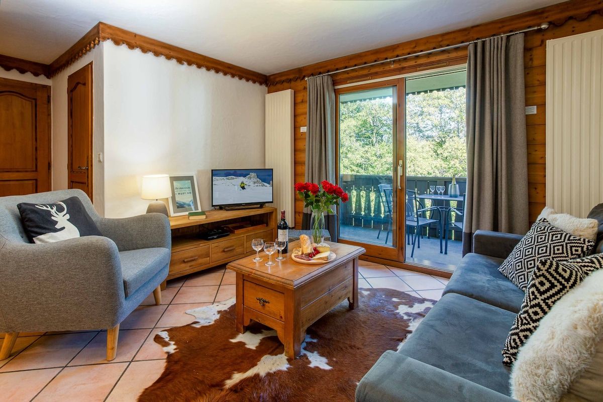A cozy living room with a sofa, a coffee table, and a television.