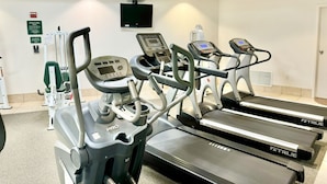 Een sportschool met loopbanden en fitnessapparatuur.
