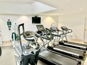 Una palestra con tapis roulant e attrezzature per esercizi.