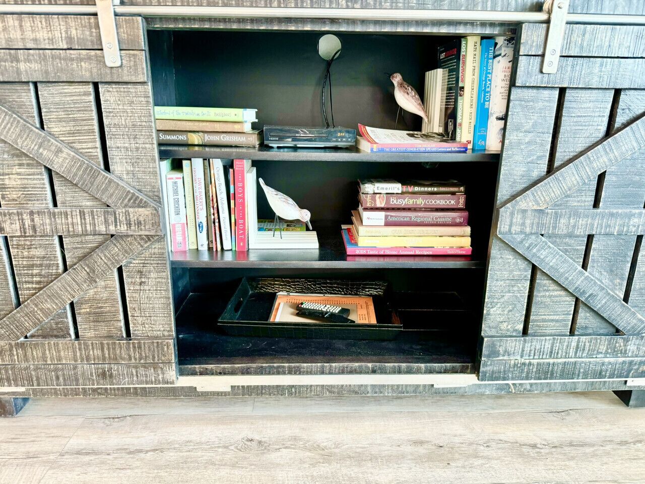 Une bibliothèque avec des livres et une télécommande.