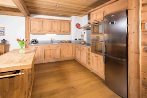 A kitchen with wooden cabinets, a stainless steel refrigerator, and a wooden countertop. - Le Kursaal Apartment, Ski/Hike, Chamonix All Year (Chamonix)