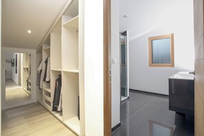 A modern interior with a hallway leading to a bathroom.