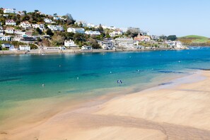 A coastal town with a sandy beach and clear blue waters.