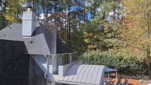 A house with a swimming pool, surrounded by trees and a clear sky. - Cozy N. Raleigh Apt. with Pool and Hot Tub. Pets welcome BBQ Grill, TV & movies (Raleigh)