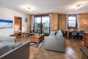 Un salon chaleureux avec un canapé, une table basse et un coin repas comprenant des chaises et une table mise pour le repas.