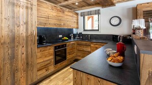 Une cuisine moderne avec des meubles en bois, un plan de travail noir et une fenêtre offrant une belle vue.