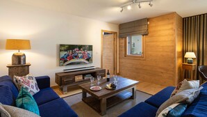 Een moderne woonkamer met een zithoek, een salontafel, een televisie en een houten accentmuur.