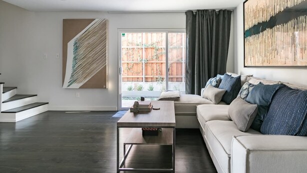 A modern living room with a sofa, a coffee table, and a staircase. - High-Spec Opulent Townhouse in Oak Lawn (Dallas)
