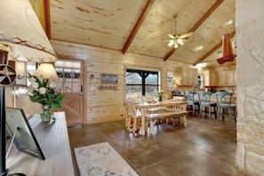 Un interior de madera con zona de comedor, cocina y un letrero que dice 'GATHER'.
