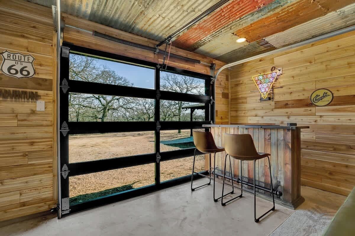 Ein rustikales Interieur mit großem Fenster, Holzwänden und einer Bar.