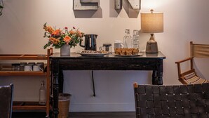 A cozy living room with a coffee table, a chair, a bookshelf, and a decorative wall with the letters "OPEN". - Kent Motel Niagara on the Lake (Niagara-on-the-Lake)
